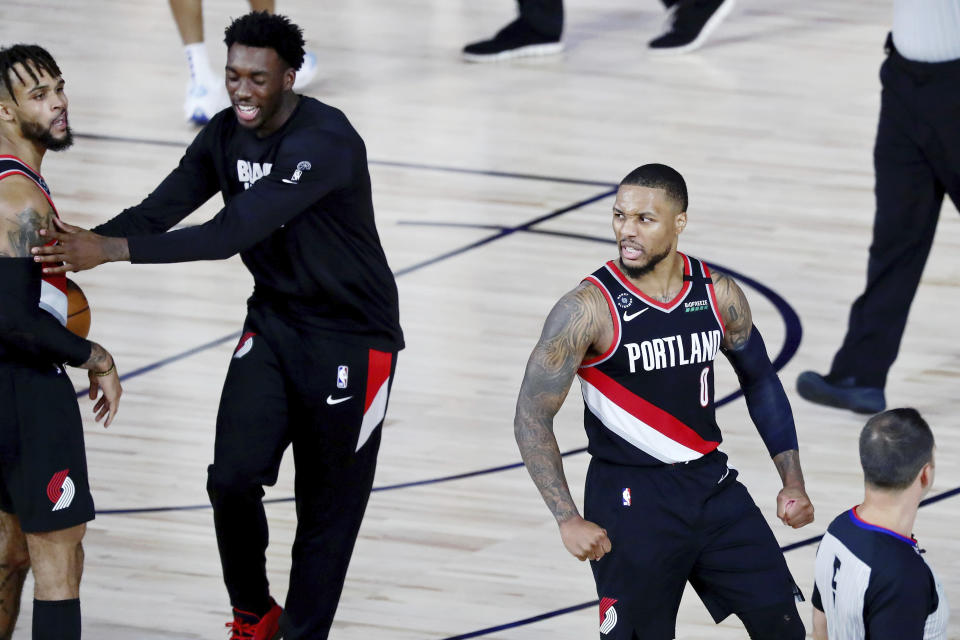 Portland Trail Blazers guard Damian Lillard (0) celebrates after their win over the Dallas Mavericks in an NBA basketball game Tuesday, Aug. 11, 2020, in Lake Buena Vista, Fla. (Kim Klement/Pool Photo via AP)