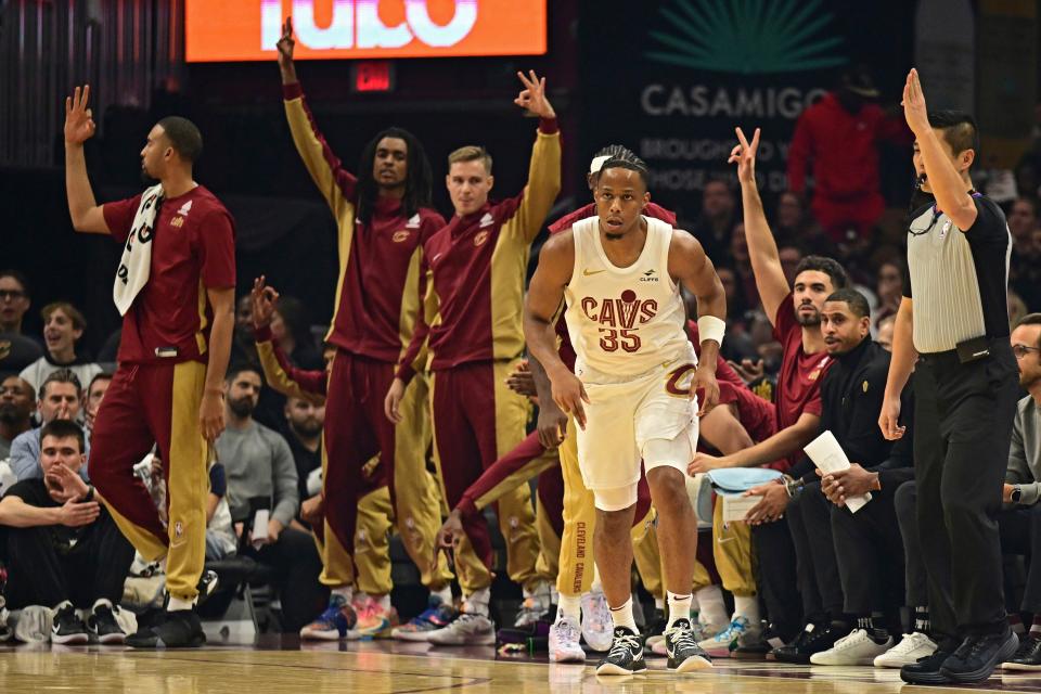 The Cleveland Cavaliers bench celebrates and forward Isaac Okoro (35) looks on after a 3-pointer against the Oklahoma City Thunder on Oct. 27, 2023, in Cleveland.