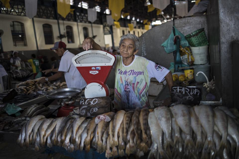 In this Sept. 7, 2019 photo, fish vendor Paulo Pedra works at in the Ver-o-Peso riverside market in Belém, Brazil. The Market brings together 2,000 stalls and traders and is located near to the old Iron market. (AP Photo/Rodrigo Abd)