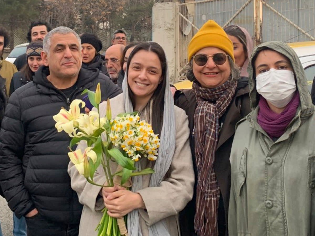 Taraneh Alidoosti, center, holds bunches of flowers as she poses for a photo among her friends after being released from Evin prison in Tehran (Gisoo Faghfouri/Sharghdaily via AP)