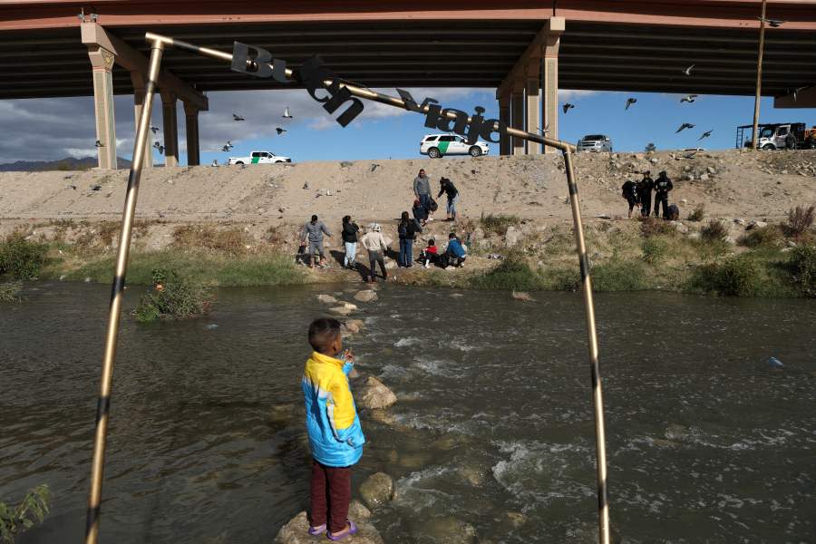 A sign reads “Good trip” as migrants walk across the Rio Grande to surrender to US Border Patrol agents in El Paso, Texas, as seen from Ciudad Juarez, Chihuahua state, Mexico, on December 13, 2022. (Photo by Herika Martinez / AFP) (Photo by HERIKA MARTINEZ/AFP via Getty Images)