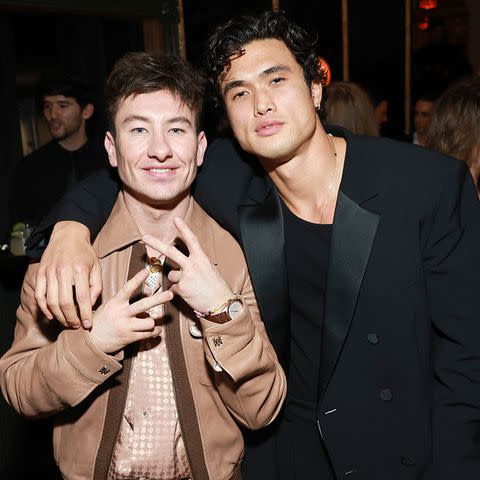 <p>Matt Winkelmeyer/Getty</p> Barry Keoghan shows off his wrist accessories while posing with Charles Melton inside the Vanities: A Night for Young Hollywood party