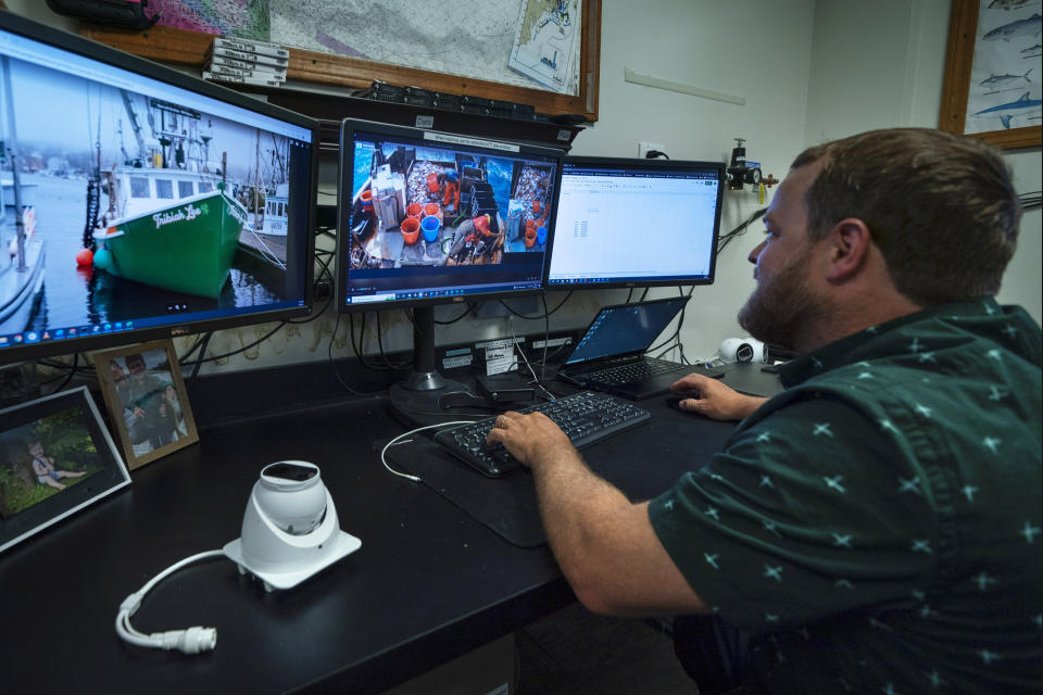 Mark Hager reviews video footage made from a camera on a New England fishing boat at his office in Portland, Maine, Wednesday, July 6, 2022. Hager's company, of New England Maritime Monitoring, uses cameras mounted on fishing boats to provide footage that can be used to help commercial vessels comply with new federal mandates aimed at protecting dwindling fish stocks. (AP Photo/Robert F. Bukaty)