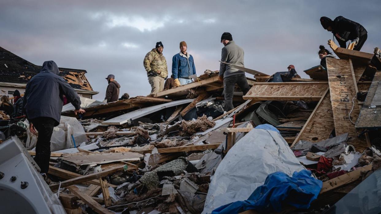 PHOTO: Residents and visitors work to clear debris in search of pets and belongings of a destroyed home in the aftermath of a tornado, Dec. 10, 2023, in Clarksville, Tenn. (Jon Cherry/Getty Images)