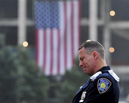 Daniel Henry, a Port Authority of New York/New Jersey police officer, pauses during a moment of silence at 9:01 am EDT, at the South reflecting pool at the 9/11 Memorial during ceremonies marking the 12th anniversary of the 9/11 attacks on the World Trade Center in New York, September 11, 2013. REUTERS/Stan Honda/Pool