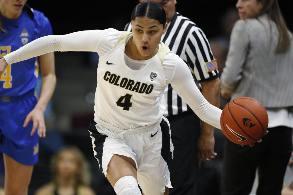 Colorado guard Lesila Finau, center, scoops up the ball as UCLA guard Lindsey Corsaro, left, pursues in the first half of an NCAA college basketball game Sunday, Jan. 12, 2020, in Boulder, Colo. (AP Photo/David Zalubowski)