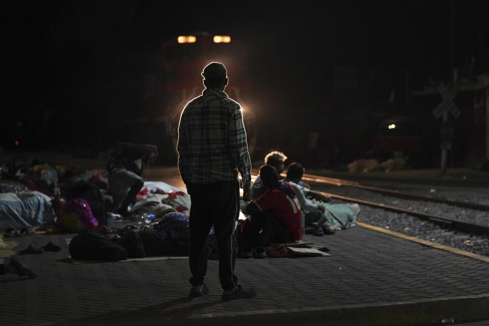 A migrant man watches as a northbound freight train pulls into Irapuato, Mexico, Saturday, Sept. 23, 2023. (AP Photo/Marco Ugarte)