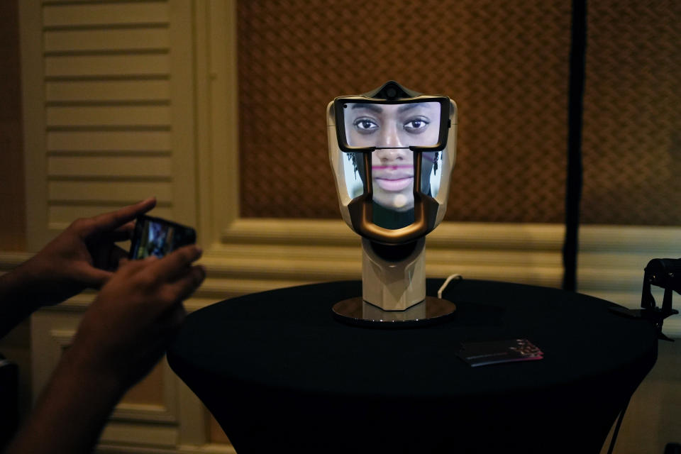 A person takes a picture of a Wehead interactive AI interface at the Wehead booth at Pepcom ahead of the CES tech show Monday, Jan. 8, 2024, in Las Vegas. The device allows for human to AI interaction. (AP Photo/John Locher)