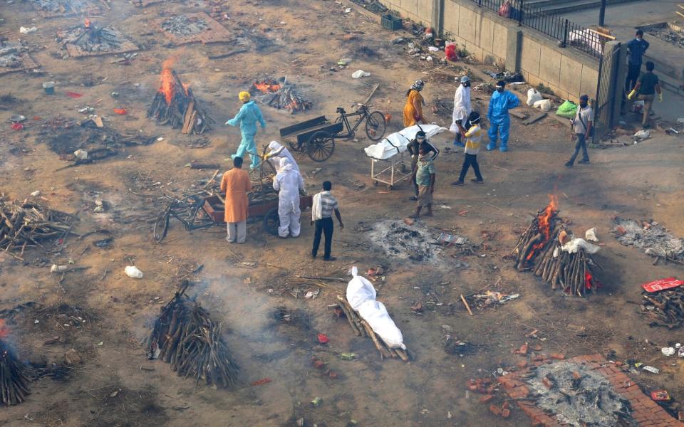 Multiple funeral pyres of those patients who died of COVID-19 disease are seen burning at a ground that has been converted into a crematorium for mass cremation of coronavirus victims, in New Delhi, India - AP