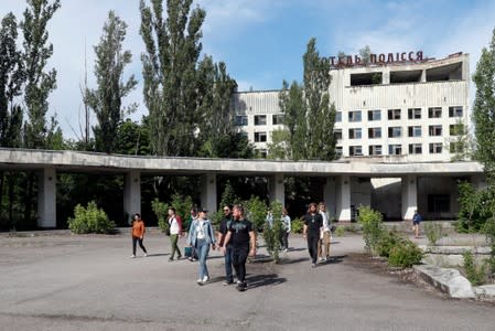 Visitors walk in the abandoned city of Pripyat, near the Chernobyl nuclear power plant