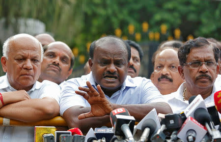 H. D. Kumaraswamy (C), Janata Dal (Secular) leader and former Chief Minister of the southern state of Karnataka, speaks with the media after handing over a letter of support from elected legislators to the state governor, outside the governor's house in Bengaluru, India, May 16, 2018. REUTERS/Abhishek N. Chinnappa