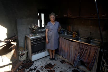 Albertina Miranda poses for a photo inside her burnt kitchen after a forest fire in Lagares, near Santa Comba Dao, Portugal October 17, 2017. REUTERS/Pedro Nunes