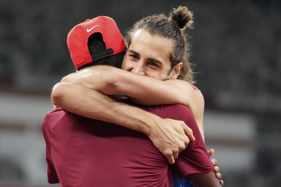 FILE - In this Aug. 1, 2021, file photo, Gianmarco Tamberi, of Italy, embraces fellow gold medalist Mutaz Barshim, of Qatar, after the final of the men's high jump at the 2020 Summer Olympics in Tokyo. In an extraordinary Olympic Games where mental health has been front and center, acts of kindness are everywhere. The world’s most competitive athletes have been captured showing gentleness and warmth to one another — celebrating, pep-talking, wiping away each another’s tears of disappointment. (AP Photo/Matthias Schrader, File)