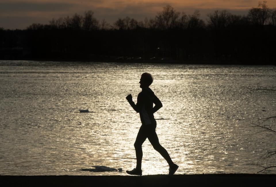 A runner's silhouette along the Ottawa River in late March 2021. Not only is the Ottawa area forecast to feel like spring Tuesday, it's forecast to feel more like May than March. (Adrian Wyld/The Canadian Press - image credit)