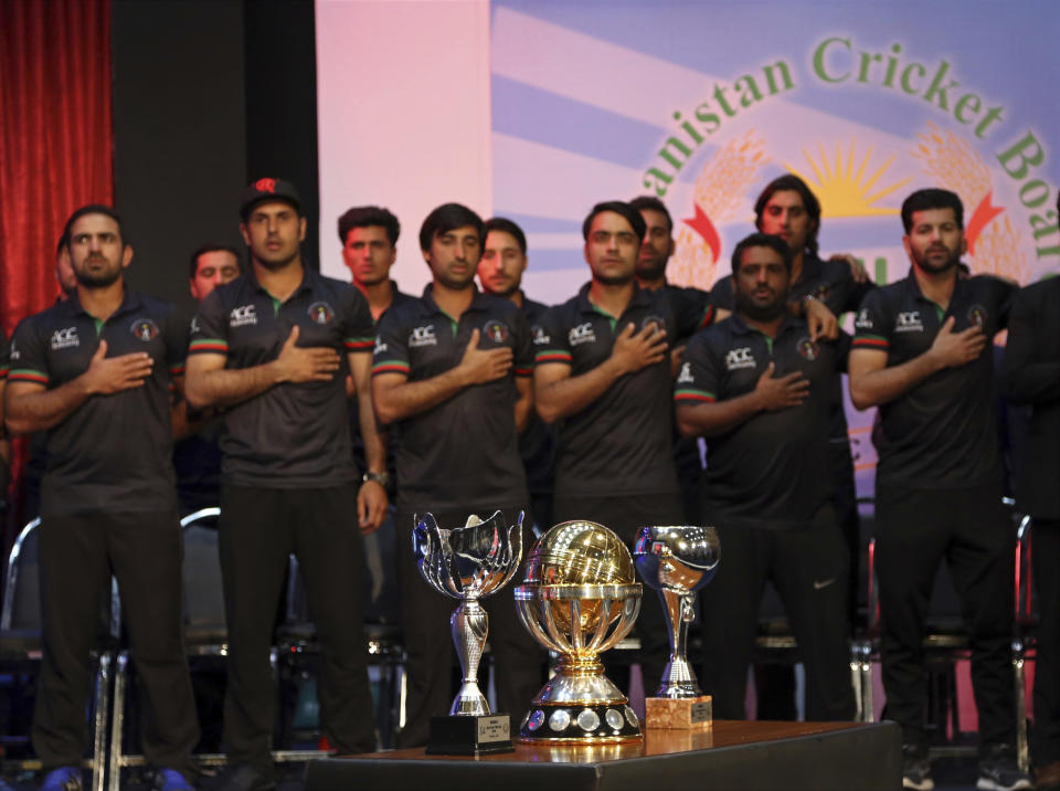 FILE - In this March 27, 2018, file photo, Afghanistan's cricket players stand for the national anthem, during celebrations following their defeat of West Indies in the final of the 2019 World Cup qualification tournament in Kabul, Afghanistan. The pandemic-affected T20 World Cup will finally kick off in Oman and the United Arab Emirates on Sunday, Oct. 17, 2021, with no clear cut favorites this time around. (AP Photo/Rahmat Gul, File)