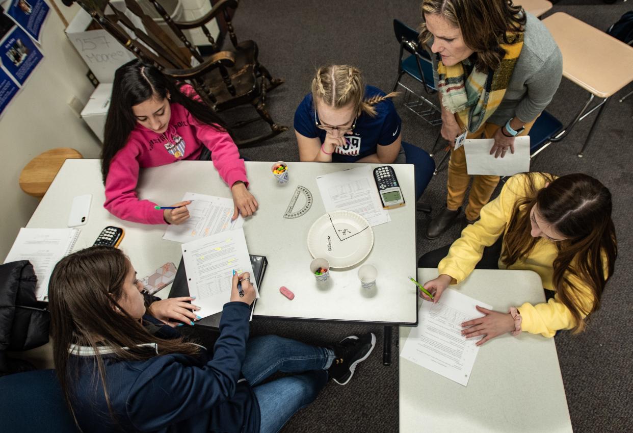 East Lansing High School math teacher Maggie Moore, top right, works with students in her Algebra 2 class, Wednesday, Jan. 9, 2020.