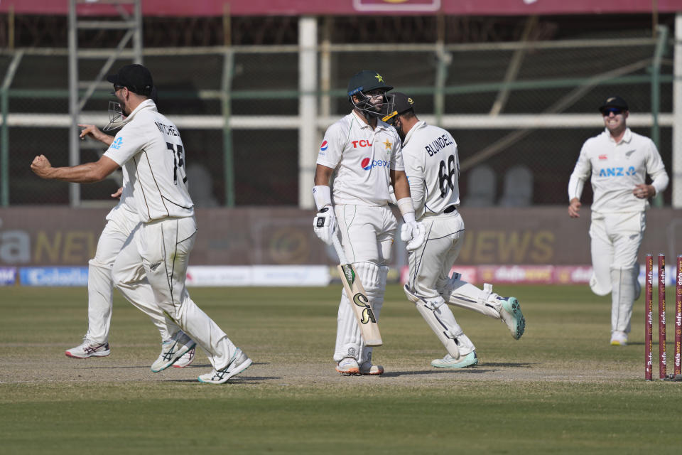 Pakistan's Imam-ul-Haq, center, reacts as New Zealand's players celebrate his dismissal during the fifth day of first test cricket match between Pakistan and New Zealand, in Karachi, Pakistan, Friday, Dec. 30, 2022. (AP Photo/Fareed Khan)