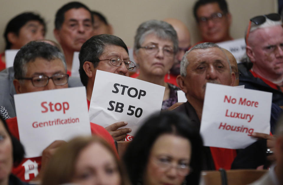 Opponents of a housing bill by State Sen. Scott Wiener, D-San Francisco, express their opinions as lawmakers debate the bill Wednesday, April 24, 2019, in Sacramento, Calif. State Sen. Mike McGuire, D-Healdsburg merged his bill, SB4 with Wiener's bill, SB50 that would increase housing near transportation and job hubs. The bill was approved by the Senate Governance and Finance Committee. (AP Photo/Rich Pedroncelli)