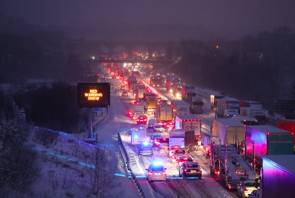 <em>Emergency vehicles manoeuvre past stationary traffic on the M80 Haggs in Glasgow, as the highest level of weather warning has been issued for Scotland and Ireland (PA)</em>