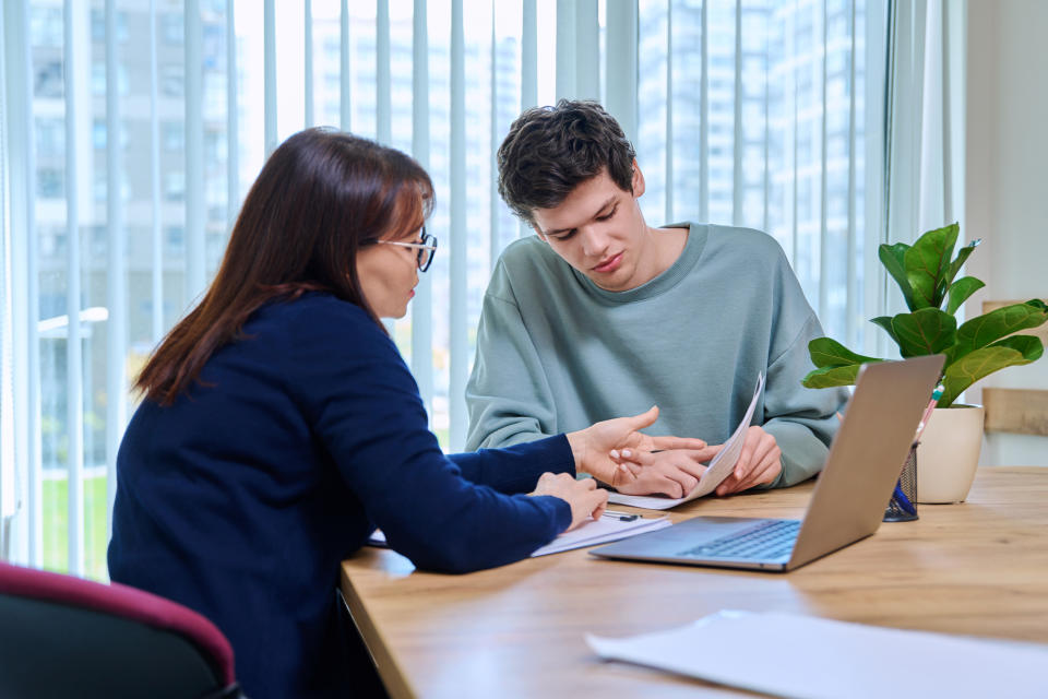 an older woman mentoring a male student