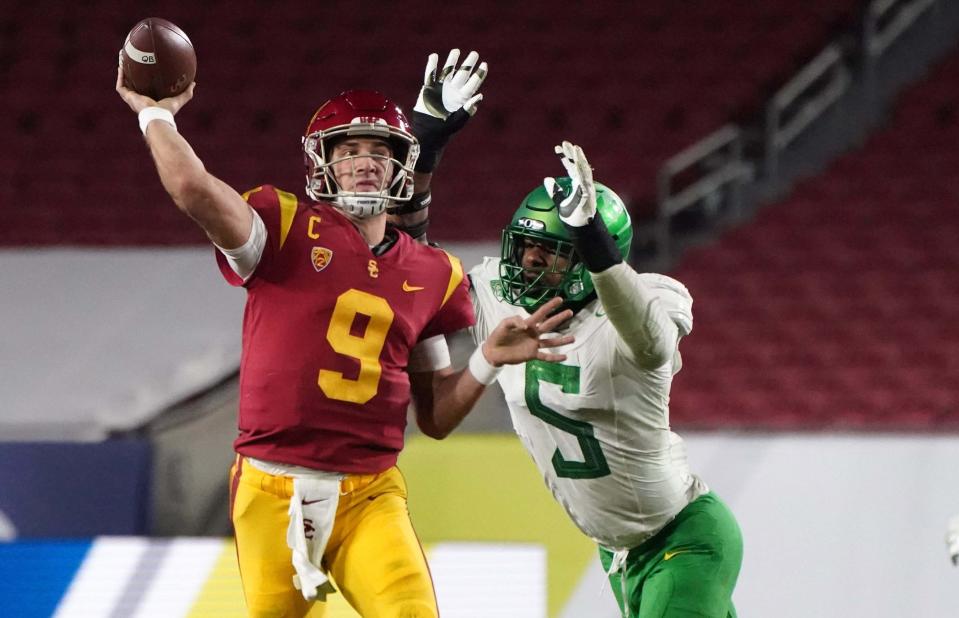 Southern California quarterback Kedon Slovis throws the ball while under pressure from Oregon defensive end Kayvon Thibodeaux in the 2020 Pac-12 title game.