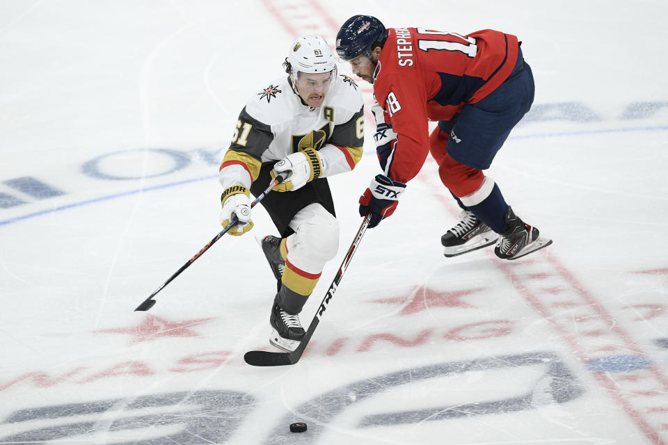 Vegas Golden Knights right wing Mark Stone (61) and Washington Capitals center Chandler Stephenson (18) chase the puck during the third period of an NHL hockey game, Saturday, Nov. 9, 2019, in Washington. (AP Photo/Nick Wass)