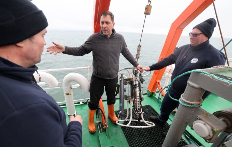 On board the fisheries research vessel Solea on the Baltic Sea, Karsten Höpfner (l-r), fisherman from Garz, Daniel Stepputtis from the Thünen Institute of Baltic Sea Fisheries and Kai Handke, fisherman from Korswandt (Usedom), talk about a measuring probe for determining the salinity, temperature and oxygen content of the water at different depths. Bernd Wüstneck/dpa