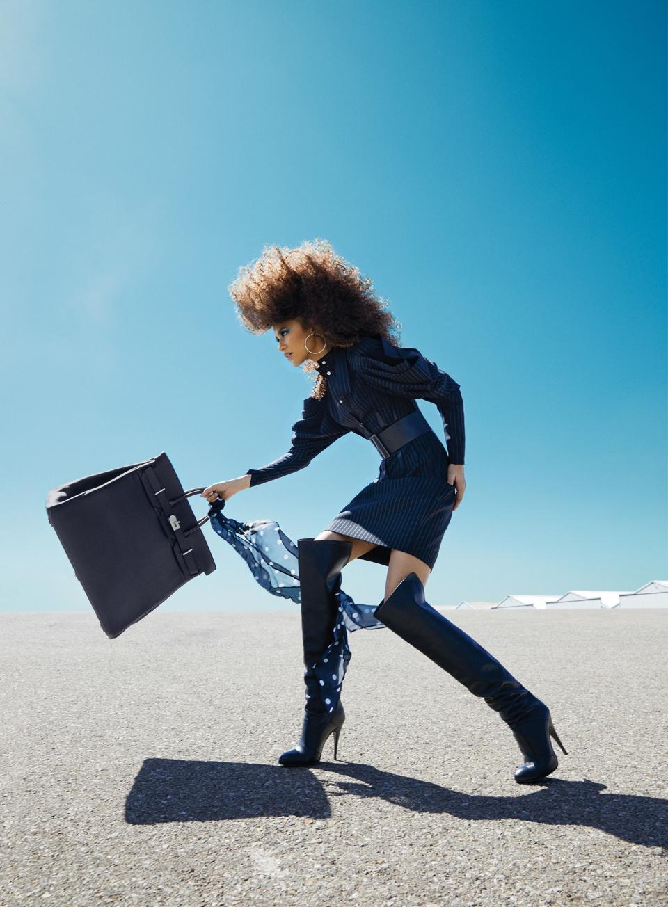 <cite class="credit">Louis Vuitton dress. Tommy x Zendaya belt, boots, and scarf. Hermès bag. Fallon earrings. Zaxie necklace. </cite>