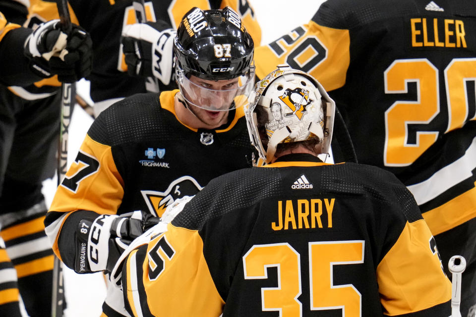 Pittsburgh Penguins goaltender Tristan Jarry (35) celebrates with Sidney Crosby (87) after recording a shutout of the Seattle Kraken in an NHL hockey game in Pittsburgh, Monday, Jan. 15, 2024. (AP Photo/Gene J. Puskar)