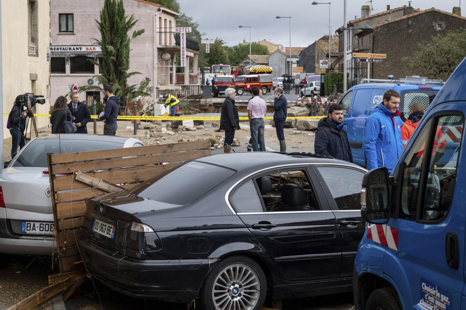 Rescue workers stand by a collpased bridge in the town of Villegailhenc, southern France, Monday, Oct.15, 2018. Flash floods tore through towns in southwest France, turning streams into raging torrents that authorities said killed several people and seriously injured at least five others. (AP Photo/Fred Lancelot)