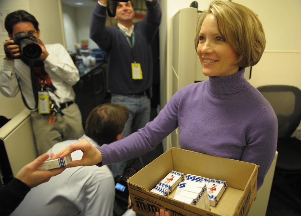 White House Press Secretary Dana Perino hands out boxes of presidential M&M candy to journalists in the Brady Briefing Room of the White House in Washington, DC January 20, 2009.