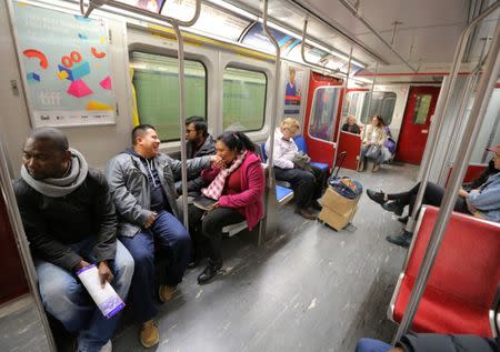 Honduran migrant Daysi Alas (C) kisses the hand of her husband Ananin Cruz while travelling to attend a church service held in Spanish in Toronto, Ontario, Canada April 8, 2017. REUTERS/Chris Helgren