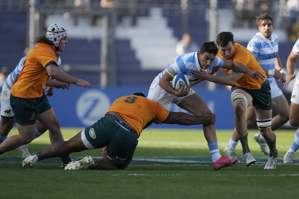 Argentina's Santiago Carreras, center, is tackled by Australia's Nick Frost, right, and Taniela Tupou, during their Rugby Championship match at the Bicentenario stadium in San Juan, Argentina, Saturday, Aug. 13, 2022. (AP Photo/Natacha Pisarenko)