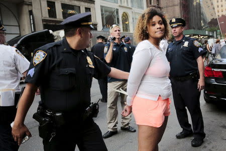 A protester is detained by New York Police Department officers during a march for Eric Garner's anniversary who was killed one year ago by police in New York July 17, 2015. REUTERS/Eduardo Munoz