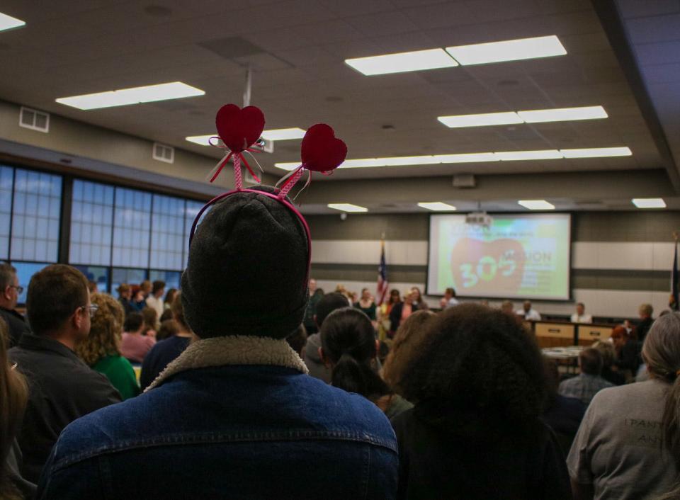 An onlooker wears a headband with heart ears among the crowd of people attending the USD 305 Board of Education meeting on Valentines Day.