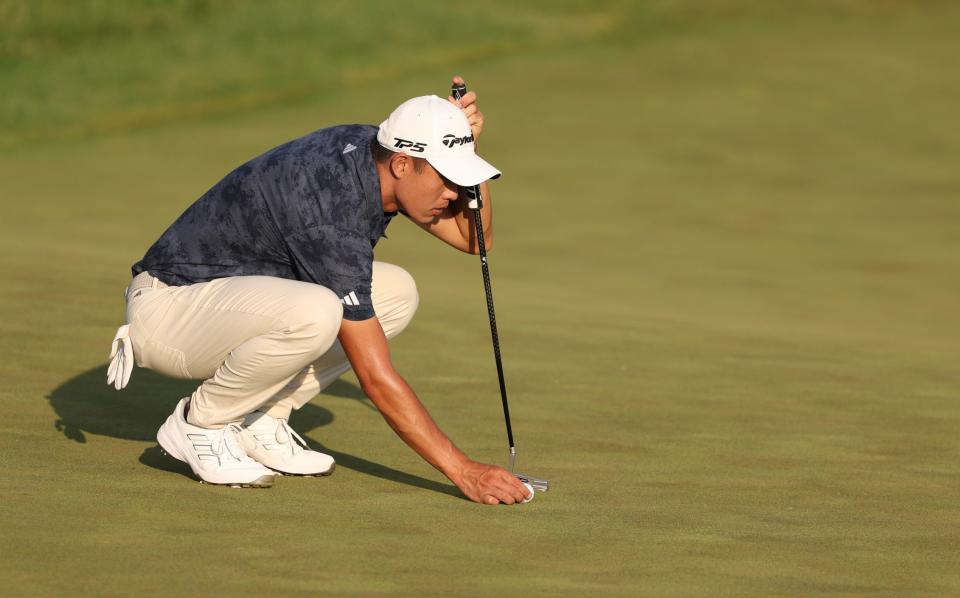 Collin Morikawa lines up a putt on 18