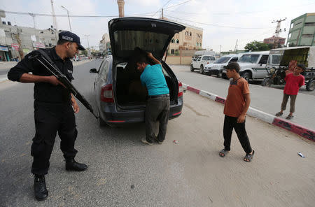 A Palestinian policeman loyal to Hamas searches a car, in Rafah in the southern of Gaza Strip August 17, 2017. REUTERS/Ibraheem Abu Mustafa