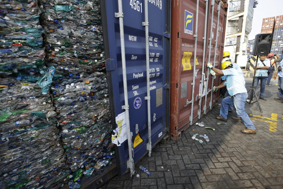 Indonesian workers lock containers full of plastic at Tanjung Priok port in Jakarta, Indonesia Wednesday, Sept. 18, 2019. Indonesia is sending hundreds of containers of waste back to Western nations after finding they were contaminated with used plastic and hazardous materials. (AP Photo/Achmad Ibrahim)