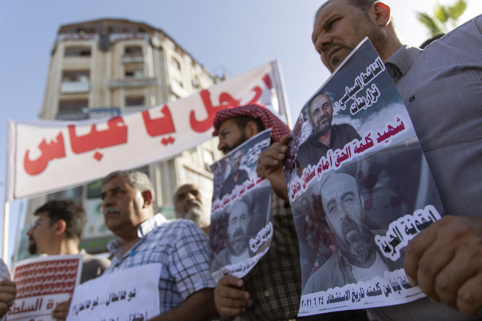 Demonstrators carry posters with pictures of Palestinian Authority outspoken critic Nizar Banat that reads "a Martyr of saying the truth infront of an ignorant Sultan," and a banner that reads "Abbas, leave," during a rally protesting his death, in the West Bank city of Ramallah, Saturday, July 3, 2021. Hundreds of Palestinians gathered to demonstrate against President Mahmoud Abbas, hoping to inject new momentum into a protest movement sparked by the death of an outspoken critic in the custody of security forces. (AP Photo/Nasser Nasser)