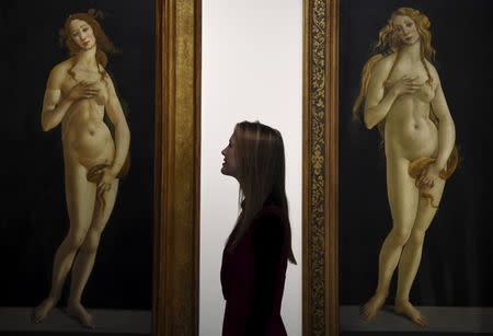 A museum employee views two paintings entitled "Venus" by Sandro Botticelli at the Victoria and Albert museum in London, Britain, March 2, 2016. REUTERS/Toby Melville