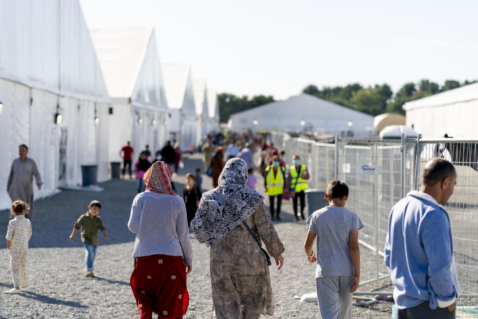 FILE - Afghan refugees walk through an Afghan refugee camp at Joint Base McGuire Dix Lakehurst, N.J., on Sept. 27, 2021. Thousands of refugees who fled Afghanistan and now live in the United States are facing an uncertain future. Congress has failed so far to create a pathway to residency for Afghans who came to America after working alongside U.S. soldiers in the war. (AP Photo/Andrew Harnik, File)