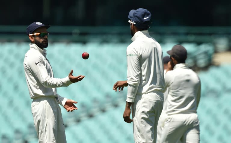 India's captain Virat Kohli (L) throws the ball to Lokesh Rahul (C) whilst fielding on the fourth day of the tour match against Cricket Australia XI at the SCG in Sydney on December 1