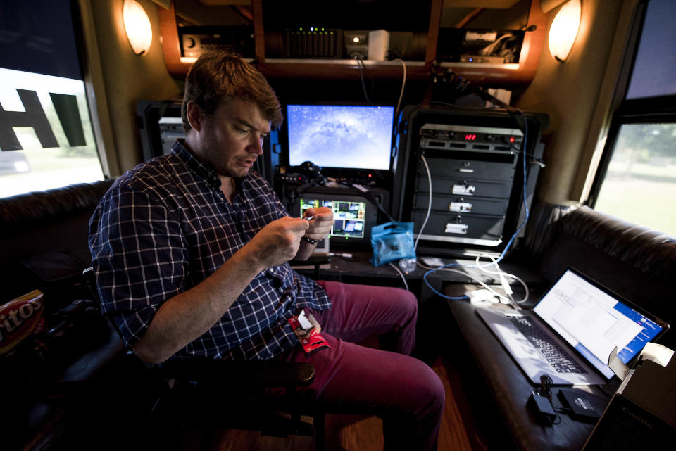 Adam Schultz edits video on the bus.&nbsp;