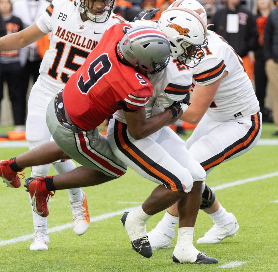 McKinley’s Dante McClellan tackles Massillon’s Ja’Meir Gamble on Saturday, Oct. 21, 2023.