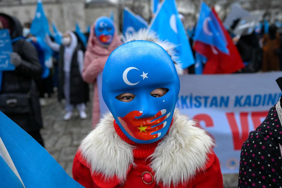 A child from the Uyghur community living in Turkey wears a mask during a protest against the visit of China's foreign minister to Turkey, in Istanbul on March 25, 2021.