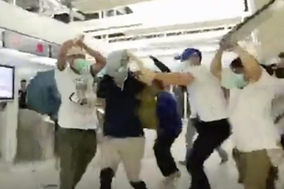 In this July 21, 2019 image made from video footage run by The Stand News via AP Video, white shirted men attacked a man dressed in black shirt at a subway station in Hong Kong. Hong Kong is reeling after a large gang of men in white shirts brutally beat dozens of people inside a train station in a shocking new twist to the city’s summer of protest.(The Stand News via AP Video)