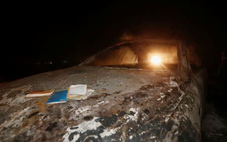 A motorist drives past the wreckage of a car burnt after a fireball from an tanker engulfed several vehicles and killed several people, near the Rift Valley town of Naivasha, west of Kenya's capital Nairobi, December 11, 2016. REUTERS/Thomas Mukoya