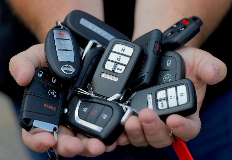 Eleven key fobs of the cars Bill Huffhine is holding at a parking lot in Troy on August 10, 2021.