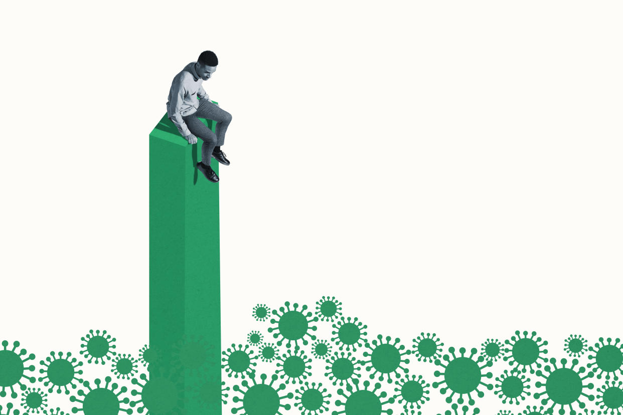 In a photo illustration, a man sits on a column, high above a sea of coronavirus.