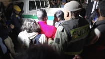 This videograb shows a bereaved family who is about to be transported home by a police pick-up truck containing the bodies of two minors in Antananarivo on August 25, 2023 following a stampede at a stadium. At least 13 people, including seven children, were killed Friday in a crowd stampede at a stadium in the Madagascar capital of Antananarivo, according to the Red Cross and a local member of parliament. (Photo by AFP) (Photo by -/AFP via Getty Images)